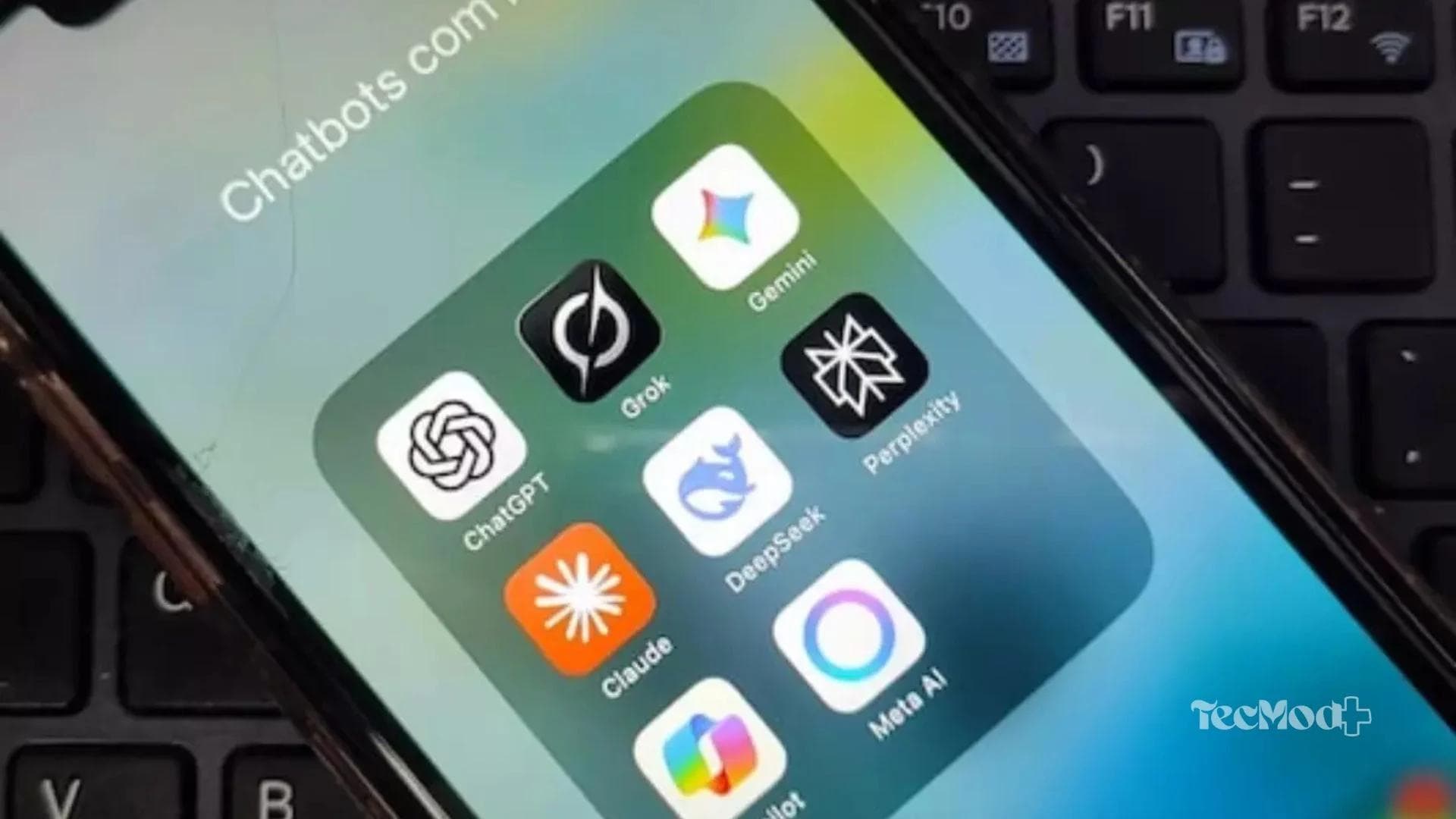 Aplicativos de Inteligência artificial em um celular sobre o teclado de um notebook.