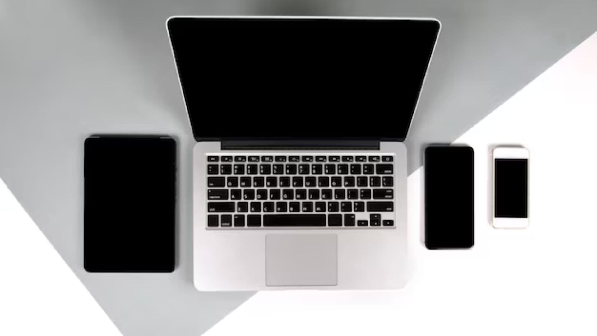 Conjunto de dispositivos (celular, tablet e notebook) sobre uma mesa